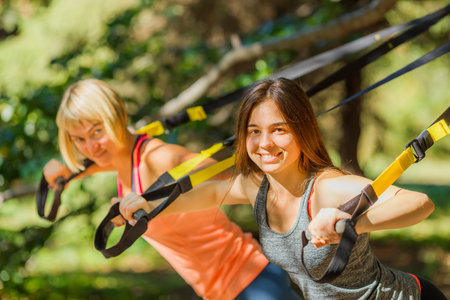 Outdoor exercises on fitness strapsの写真素材