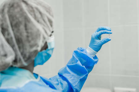 A scientist examines a small tube after the DNA amplifier and rna. A scientist in the laboratory looks at a small test tubeの写真素材