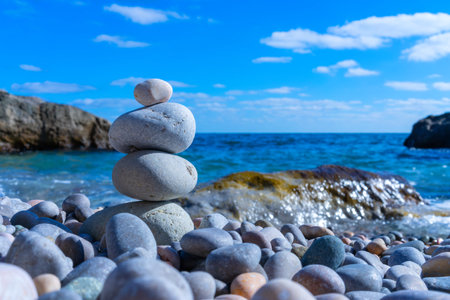 A pebble pyramid built by a man stands on the seashore