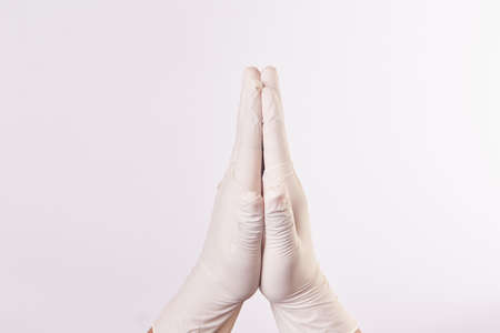 Hand of a man with latex glove clasps hands in prayerの写真素材