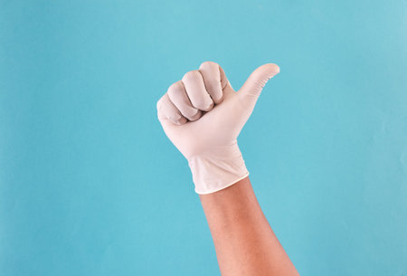 Man's hands with latex gloves raising thumb