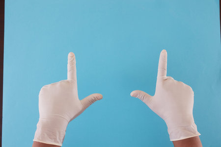 Man hands with latex gloves pointing.