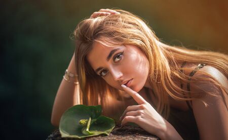A girl in a park near a pond with water liliesの写真素材