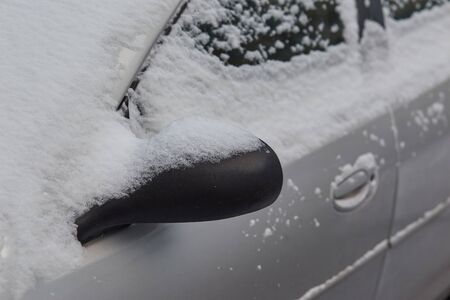Car covered with snow. Car mirror sticking out of the snow. .の写真素材