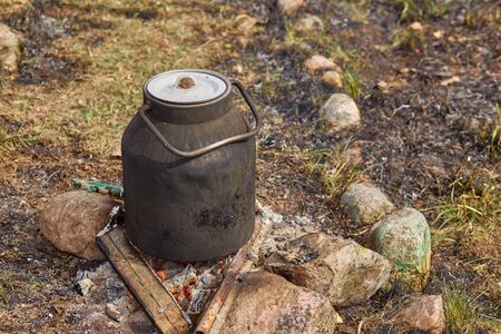 ukha is cooked in the old blackened cans on fireの写真素材