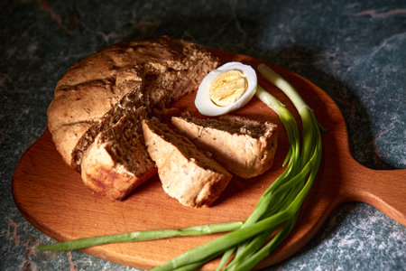 Fresh bread, greens, egg on a cutting board.の写真素材