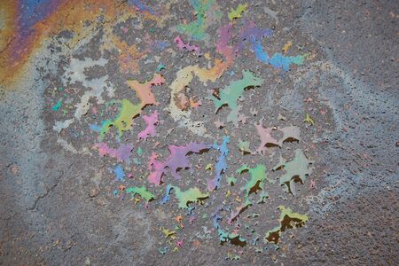 Colored oil stains on the asphalt, the color of the gasoline stain on the pavement road as a texture or background.Close-up of the oil stain on the pavementの写真素材