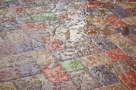 Sidewalk tiles covered with and ice.Background of a snow-covered sidewalk close-up.Selective focusの写真素材