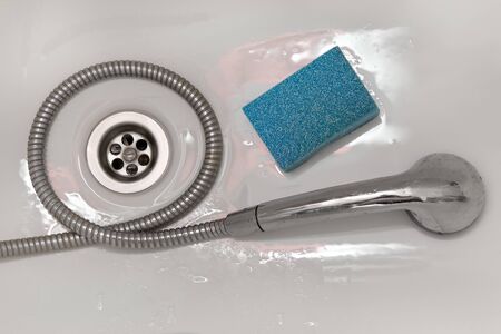 Wet shower head lying in the shower stall sponge for washingの写真素材