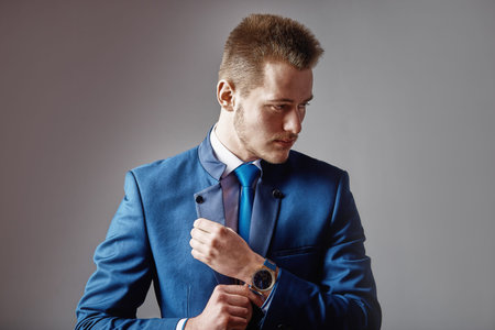 A man dressed in a suit over dark grey background.