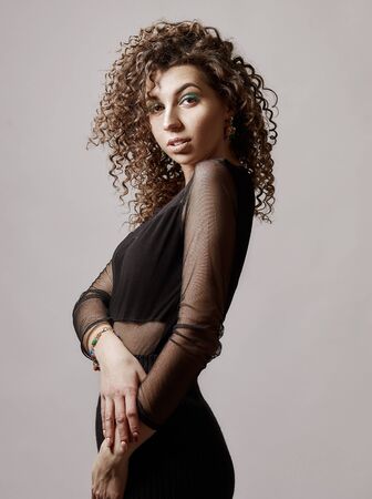Happy mixed race girl with curly hair is hugging herself.の写真素材