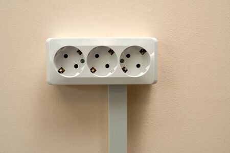 A block of white outlets consisting of three standard outlets with groundingの写真素材