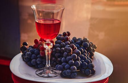 A glass of red wine on the background of grape.の写真素材