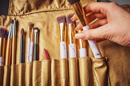 Cosmetic Makeup Brush in female hand on recruitment background.の写真素材