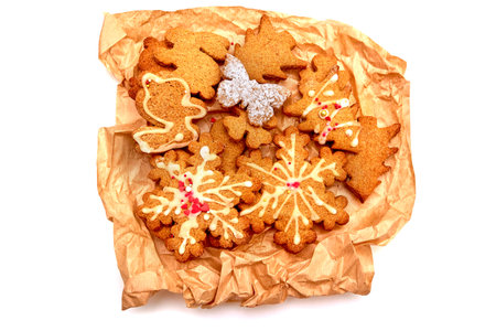 Gingerbread cookies on baking paper. Snowflake, star, herringbone, bunny. Isolated white background.の写真素材