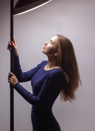 Young woman adjusts light in studio from lighting equipmentの写真素材