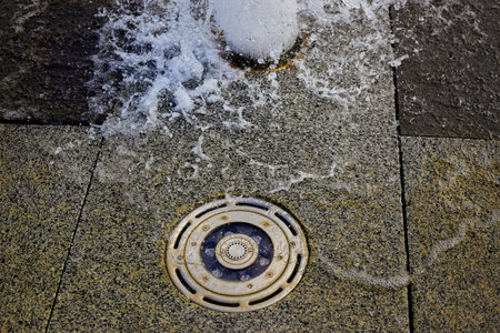 Water splashes in the evening in the city fountain close up. Selective focus