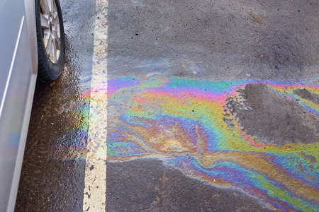 Colorful gas stain on wet asphalt. Oil stain caused by a leak under a carの写真素材