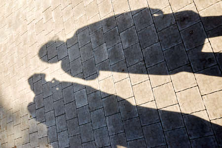 two shadows from figures on paving slabsの写真素材