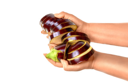 Human hand holding ripe sliced eggplant isolated on white background in studio. Healthy food and...