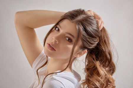 Portrait young woman in studio on graybackground. Youth concept