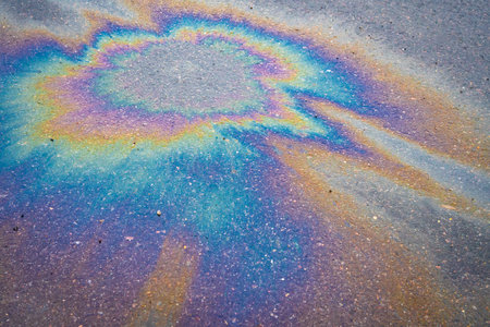 Beautiful abstract stain of motor oil, gas or petrol spilled on the asphalt. Marbling abstract...