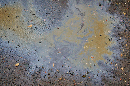 Beautiful abstract stain of motor oil, gas or petrol spilled on the asphalt. Marbling abstract...