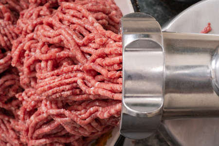 Minced meat coming out from modern electric grinder. Healthy fresh homemade minced meat. Selective focusの写真素材