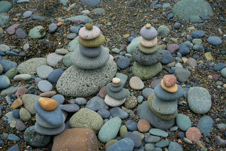 Zen balancing pebbles nearby on the sea beach