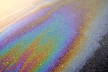 Oil stain on the asphalt,-shaped colored gasoline stains on an rainbow asphalt road as a texture or...