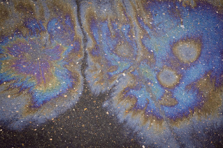 Oil rainbow gasoline spill on asphalt. Environmental pollution conceptGasoline flows on the asphalt. Rainbow stains of oil and gasoline.の写真素材