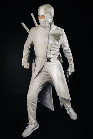 Ninja posing for a photo on a black background, a male ninja in a white kimono.