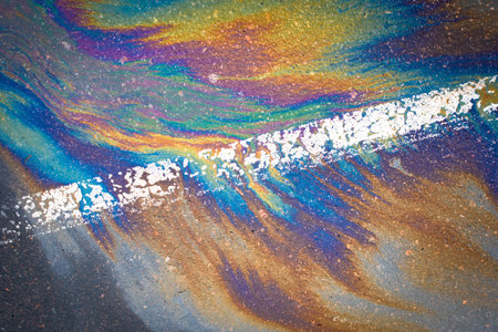 Oil spill on dark wet asphalt, parking lot with dividing lines.の写真素材
