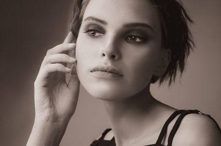 Monochrome portrait of a beautiful young woman without makeup on a neutral gray backgroundの写真素材