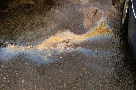 Leakage of oil or gasoline from the car on the asphalt in the parking lot.の写真素材
