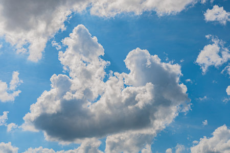 Sky with huge white clouds in summer on a sunny day. Huge white clouds against the background of the sunny skyの写真素材