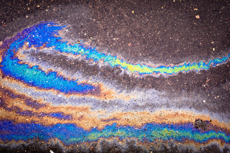 Texture of colorful petrol oil spill on wet pavement.の写真素材