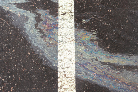 Oil spill on wet asphalt, parking lot with dividing line.の写真素材