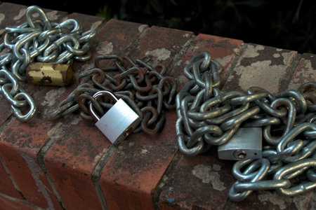 Padlock and chain on a brick wall, closeup of photoの写真素材