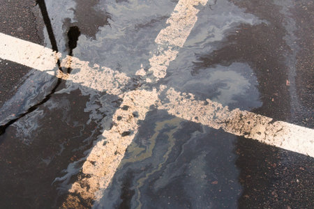Oil spill on wet asphalt, parking lot with dividing line.の写真素材