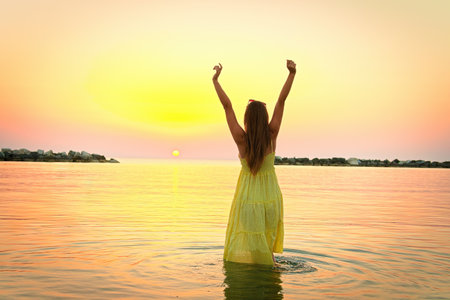 beautiful girl in the water at sunrise.の写真素材