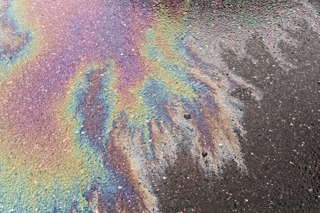 Texture of colorful petrol oil spill on wet pavement.の写真素材