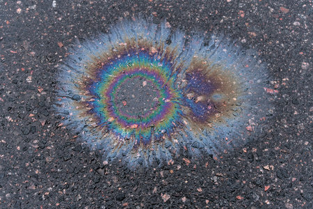 Rainbow stain of gasoline on the asphalt. Gasoline stains pollute the environmentの写真素材