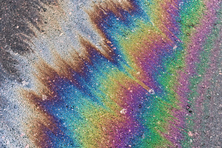 Gasoline pollution, oil, rainbow gasoline leak in the form of a glow on the sidewalk