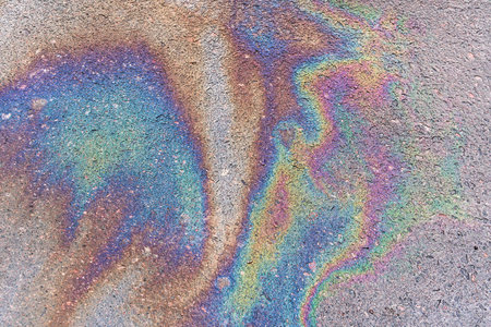 Abstract colored background of leaked gasoline on wet asphalt close-up.の写真素材