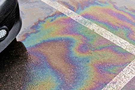 Leakage of oil or gasoline from the car on the asphalt in the parking lot. The concept of environmental pollution.の写真素材