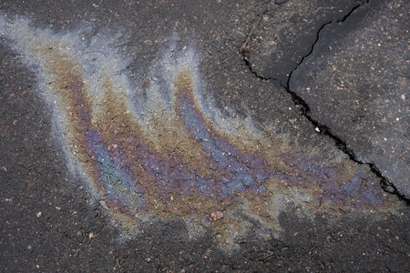 Leakage of oil or gasoline from the car on the asphalt in the parking lot. The concept of environmental pollution.の写真素材