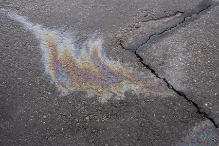 Leakage of oil or gasoline from the car on the asphalt in the parking lot. The concept of environmental pollution.の写真素材