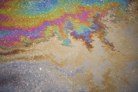 Abstract colored background of leaked gasoline on wet asphalt close-upの写真素材