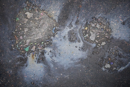 Colored oil stains close up, the color of the gasoline stain on the pavement road as a texture or background.の写真素材
